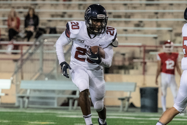 Wearing his white Penn jersey, running back Laquan McKever carries the back in the backfield.