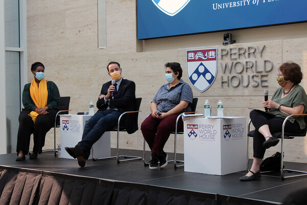 Meg Guliford, John Gans, Wazhmah Osman and Trudy Rubin sit in chairs on a stage with the words Perry World House on the wall behind them