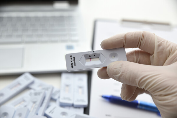 Gloved hand holding a SARS-CoV-2 antibody test.