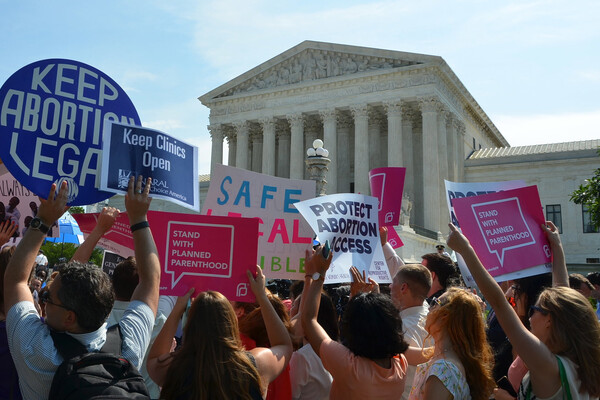 Pro-choice activists hold signs reading "keep abortion legal' and "protect abortion access' in front of the US Supreme Court building
