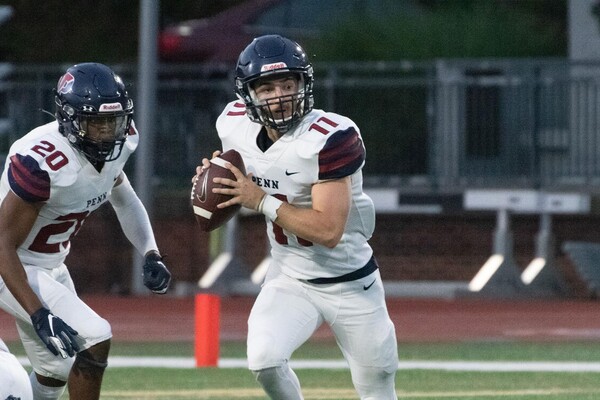 Quarterback Andrew Paolini moves to the right in the pocket with the ball and looks down the field for an open receiver.