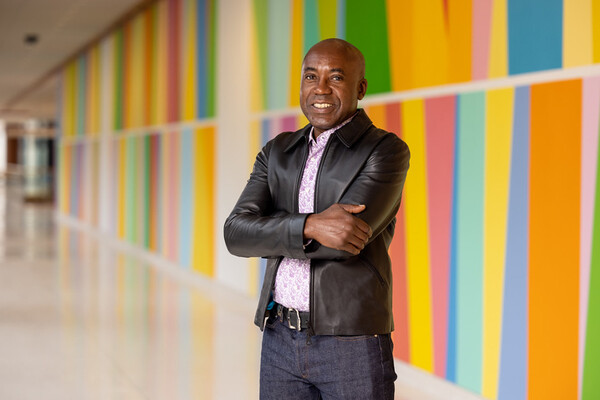Odili Odita stands in front of his mural in the Penn Medicine Pavilion.