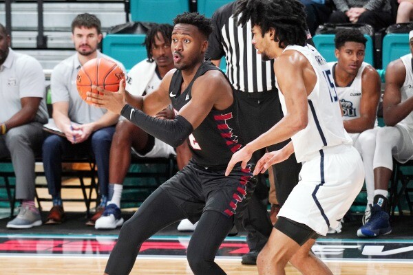 Guard Jonah Charles, while being guarded by a defender, makes a move to the basketball with the ball against Old Dominion.