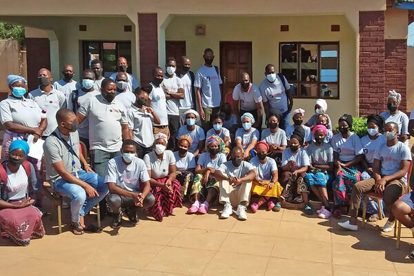 Group of people wearing masks outside a building in Malawi.
