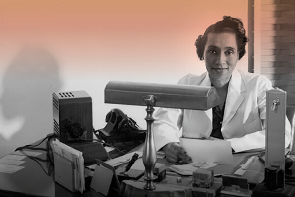 Helen O. Dickens in a white coat at her work desk.