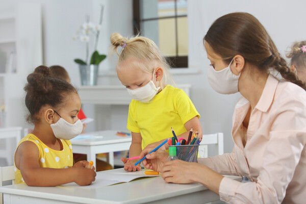 Preschool children work on art with a teacher