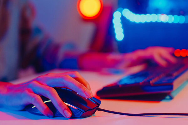 Person’s hand using a mouse and a keyboard at a computer.