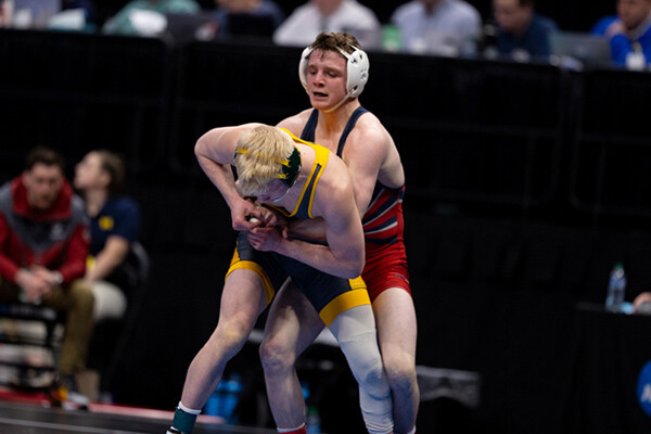 At the NCAA Championships, sophomore CJ Composto wrestles with an opponent while standing, with his arms wrapped around his opponent's waist.