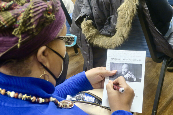 An audience member writes on their program.