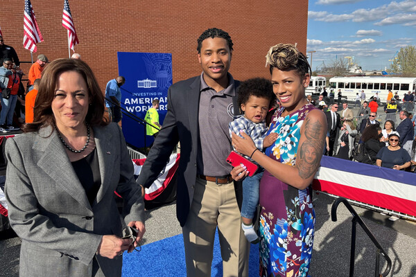 Vice President, Kamala Harris stands at a ceremony with William Griffin and his wife, who is holding their son.