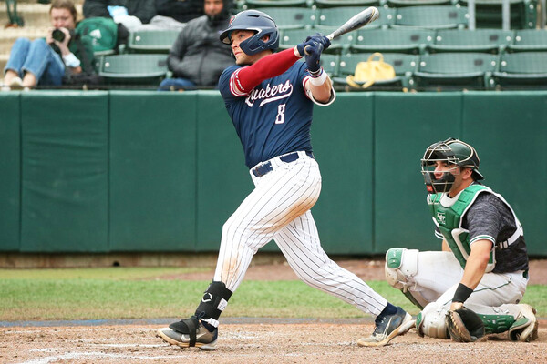 Wearing his blue Penn jersey, Wyatt Henseler watches the ball from the batters box after swinging at a pitch.