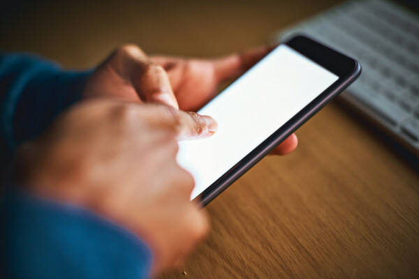 Hands texting on a smartphone.
