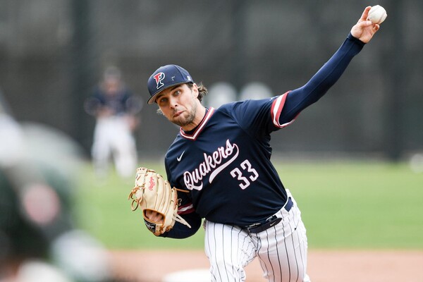On the mound wearing his blue Penn jersey, Joe Miller throws a pitch.