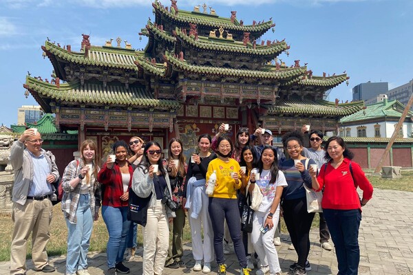 Penn Global seminar students hold up cups outside the Winter Palace 