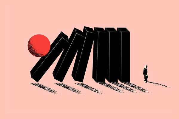 Dominoes about to fall on a tiny person holding a briefcase