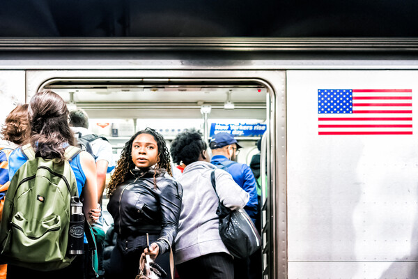 Unmasked people entering and exiting a subway car.