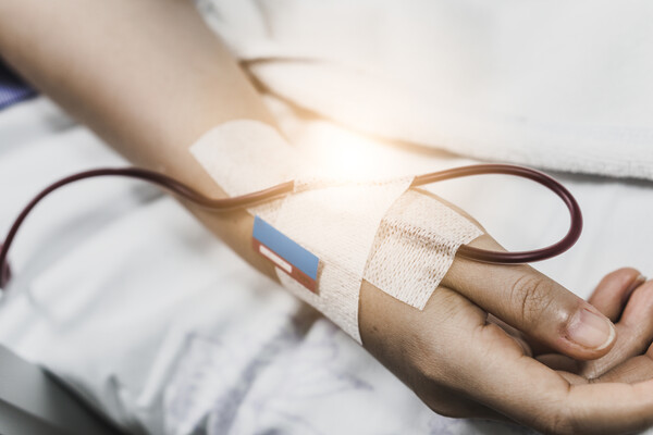 Hospital patient with IV in arm.