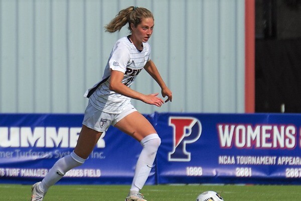 During a home game at Rhodes Field, midfielder Sara Readinger kicks the ball down the field.