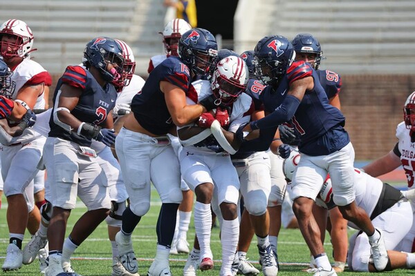 Against Colgate at Franklin Field, a host of Penn defenders tackle a Colgate player with the ball.