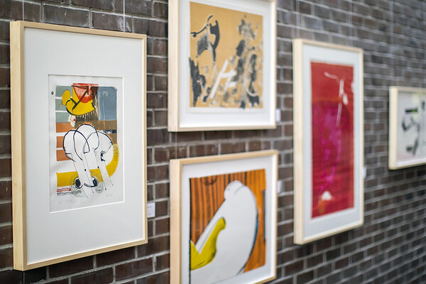 Artwork hangs on brutalist brick wall