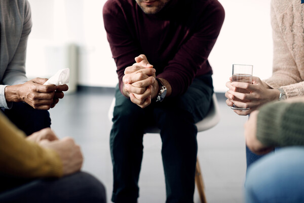 Four people seated in a support group setting.