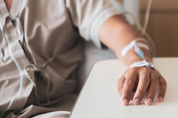 Person’s arm with a chemo drip in hand.