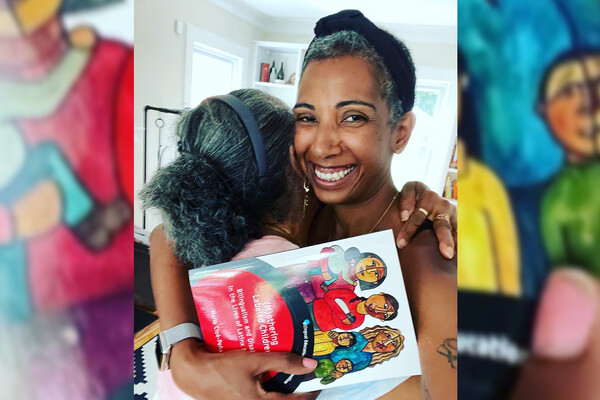 María Cioè-Peña hugs her mother, holding a copy of her book.
