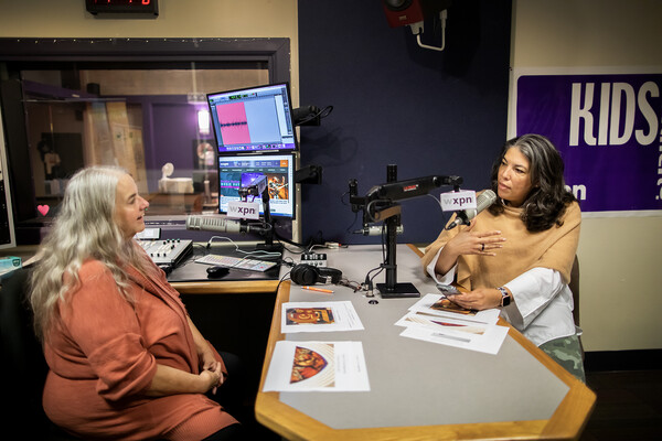 Gwendolyn DuBois Shaw and Kathy O'Connell speaking into microphones in the WXPN radio studio. 