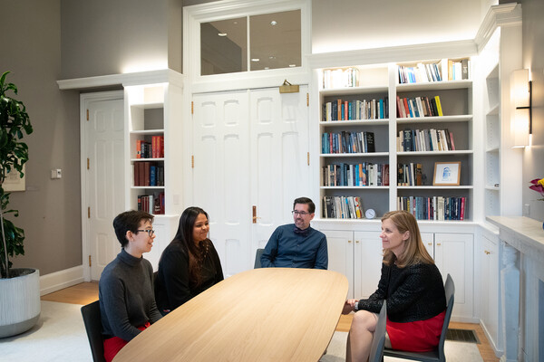 Two students, Mark Lo and Liz Magill talking while seated at a table.