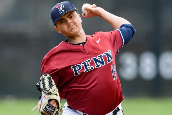 Wearing his red Penn jersey, Owen Coady of the baseball team prepares to throw a pitch from the mound.