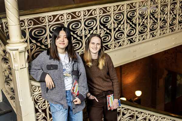 Gemma Hong and Sophie Young standing together holding copies of their book.
