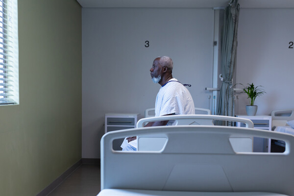 African American patient sitting on a hospital bed.