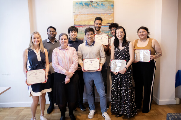 A group of students clustered around each other holding certificates. 