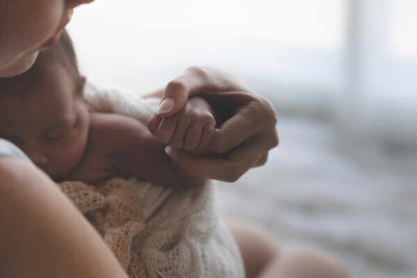 Parent holding newborn baby.