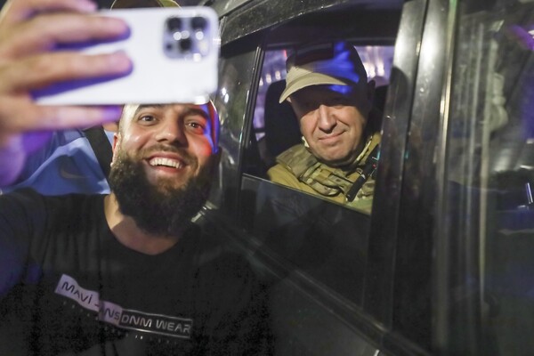 Yevgeny Prigozhin, the owner of the Wagner Group military company sits inside a military vehicle posing for a selfie photo with a local civilian on a street in Rostov-on-Don, Russia