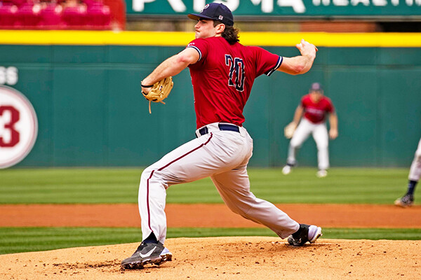 Wearing his red Penn jersey, Ryan Dromboski prepares to throw a pitch from the mound.