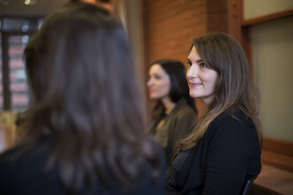 Historian Ada Kuskowski listens to a speaker sitting next to her at a table.