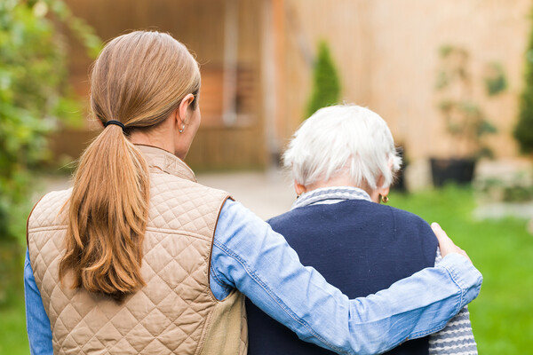 A person walking with an elderly person.