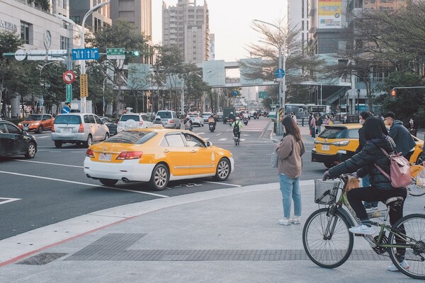 A busy street in Taipei, Taiwan, with people driving, biking, and walking