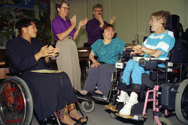 Judy Heumann is applauded during her swearing-in as U.S. Assistant Secretary for Special Education and Rehabilitative Service in 1993. 