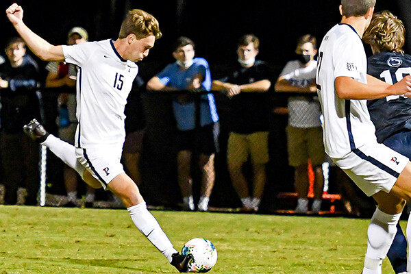 Against Penn State, Michael Hewes draws his foot back and prepares to kick the ball.