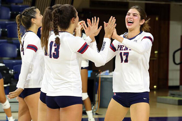 Members of the volleyball team high five after a big play.