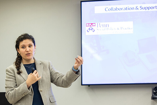 Millan AbiNader presenting next to a screen.