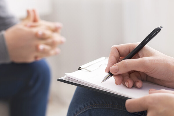 Therapist writes notes during session.