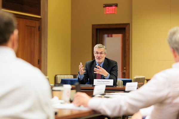 Cary Coglianese speaking to two people at a conference table.