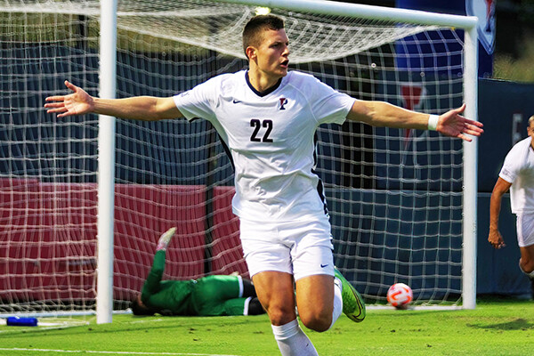 Stas Korzeniowski extends his arms in celebrating after scoring a goal during a game.