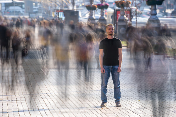 Man stands on crowded street.
