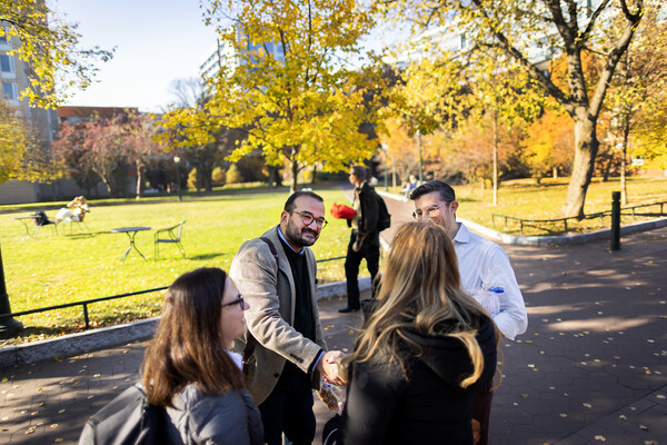 Harun Kucuk shakes hands with people on Locust Walk