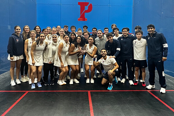 Members of the men's and women's squash teams pose on the court at the Penn Squash Center.