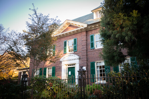 Red brick exterior of Fox-Fels Hall on Penn campus, a Georgian style mansion with green shutters and white trim.